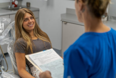 A patient speaks with a staff member at Dr. Clarizio's office in the exam and operating room.